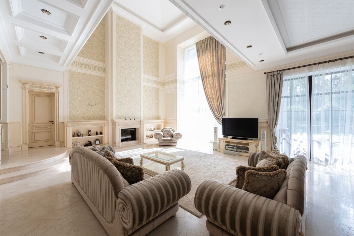A bright living room with a sofa set and tall windows